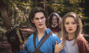 Man and woman posing in the foreground while an evil entity approaches from behind. 